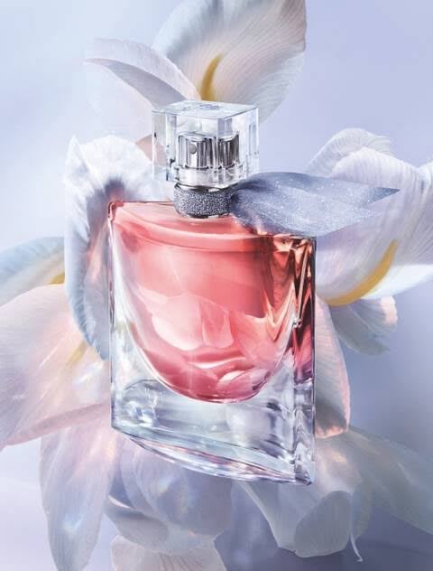 Frasco do clássico perfume gourmand La Vie Est Belle às margens do rio Sena